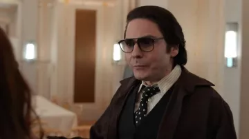Les looks de Becoming Karl Lagerfeld : Daniel Brühl porte une cravate noire à pois blancs pour interpréter le couturier dans l'épisode 1, de la saison 1 de la série Dinsey+