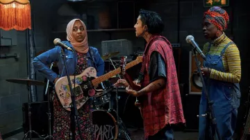 Tenues We Are Lady Parts : Anjana Vasan porte une veste bleue pour jouer Amina dans la saison 1