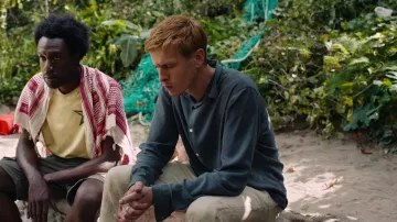 Triangle of Sadness Movie Outfits: Carl (Harris Dickinson) is wearing Blue long sleeve shirt