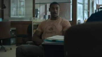 Rebel Ridge Wardrobe: Terry Richmond (Aaron Pierre) is wearing Hornets T-shirt in the Netflix' movie