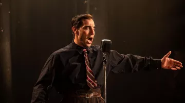 Los looks de la película Monsieur Aznavour: la corbata a rayas que lleva el cantante Charles Aznavour (Tahar Rahim) durante uno de sus conciertos