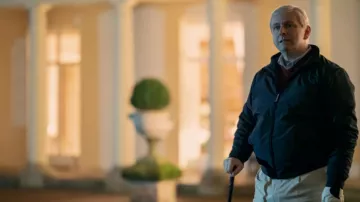 Atuendos de A Very Royal Scandal Temporada 1: El príncipe Andrés (Michael Sheen) lleva una chaqueta Harrington con cremallera en el episodio 3 de la temporada 1