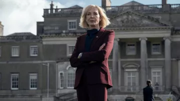Vestuario de la serie de televisión The Diplomat: Grace Penn (Allison Janney) lleva un blazer y un traje de pantalón burdeos en la temporada 2