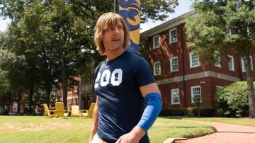 Tenues de la série télévisée Chad Powers : Glen Powell porte un t-shirt bleu Nike 200 pour incarner le quarterback Chad Powers dans la saison 1