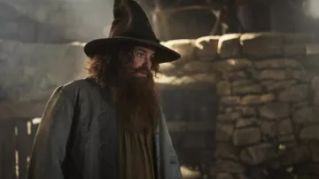 The Lord of the Rings: The Rings of Power Outfits: Tom Bombadil (Rory Kinnear) wears a pointed hat in season 2, episode 6 of the TV series