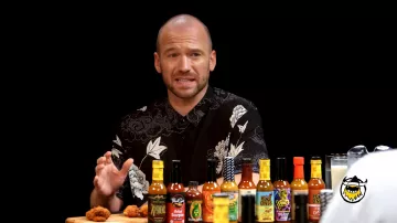 Sean Evans wears beautiful Black printed t-shirt in Hot Ones TV show with Zlatan Ibrahimović