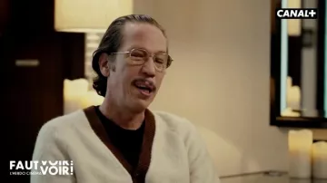 Reda Kateb porte un cardigan blanc crème en maille bouclette avec bordure marron dans l'émission Faut Voir ! - L'hebdo cinéma avec Antoine de Caunes