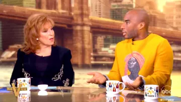 Charlamagne tha God porte un pull à col rond jaune avec un imprimé femme noir dans l’émission télévisée The View