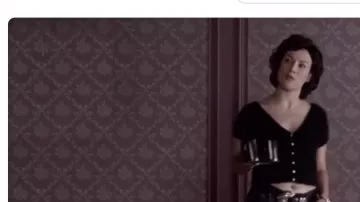 Pull noir à col en V porté dans la scène du café de Violet (Jennifer Tilly) dans Bound
