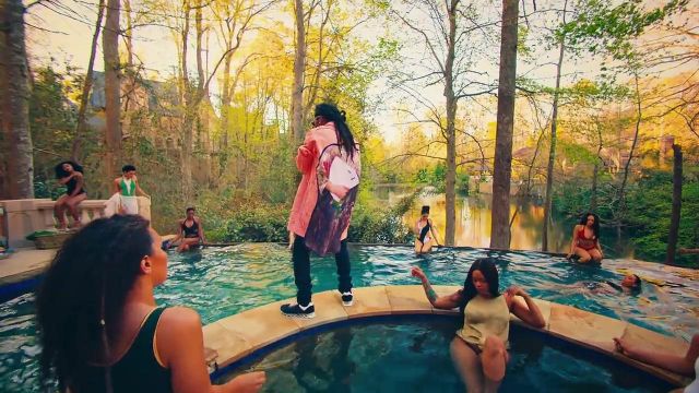 The peach/orange colored coat that Takeoff wear in the pool scene in the I Get the Bag music video of Gucci Mane