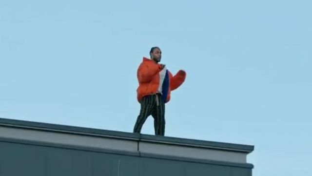 orange puffy manteau porté par Kendrick Lamar comme on le voit dans le Roi est Mort Video Clip de Jay Rock