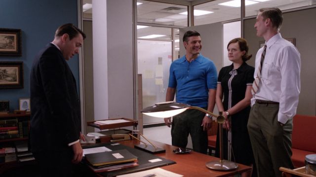 The black dress with white stripes worn by Peggy Olson (Elizabeth Moss) in the series "Mad Men" (S05E01)