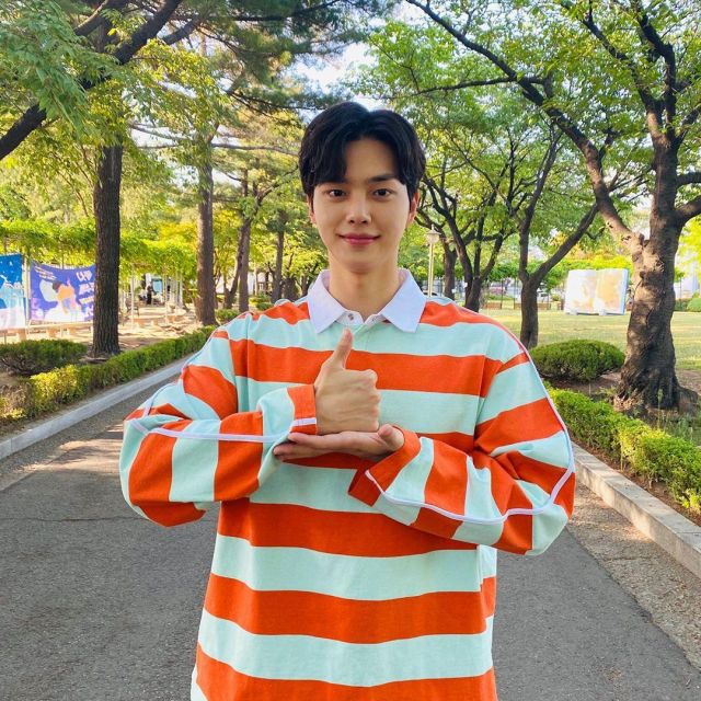 The striped polo shirt orange and green worn by Song Kang on his account Instagram @songkang_b