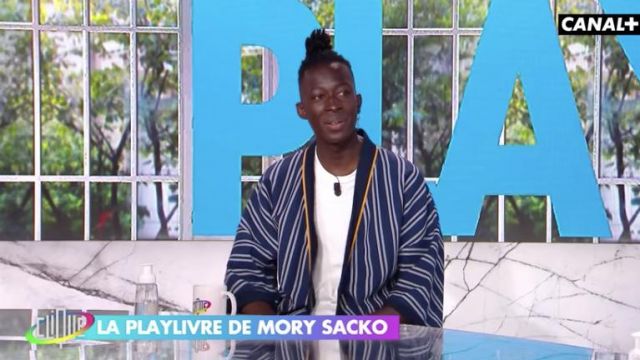 Le kimono / cardigan bleu rayé porté par Mory Sacko dans Clique TV