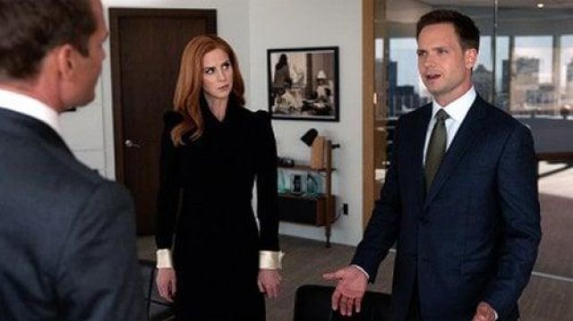 The black dress with epaulets and end of white sleeve of Donna Paulsen (Sarah Rafferty) in Suits, lawyers to measure (Season 7 Episode 13)