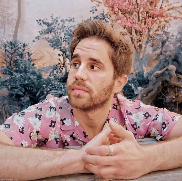 Pink button-up collared shirt with navy blue and flower pattern worn by Ben Platt on the Instagram account of @benplattdefensesquad