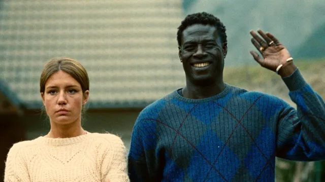 The green and blue diamond sweater worn by Jimmy (Moustapha Mbengue) in the movie The Five Devils