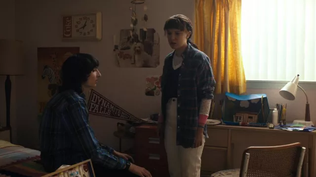 The blue-collared top worn by Eleven (Millie Bobby Brown) in the series Stranger  Things (Season 4 Episode 9)