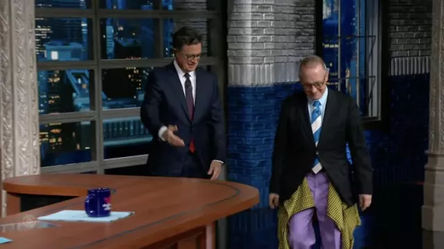Extravagant pants in purple and yellow plaid worn by David Sedaris in The Late Show with Stephen Colbert
