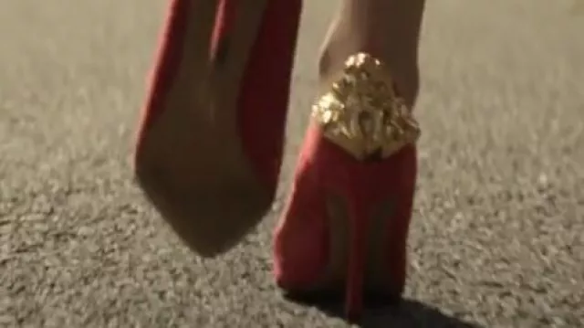 Red high heels with gold embossing worn by a character as seen in The Sandman TV series (S01E09)