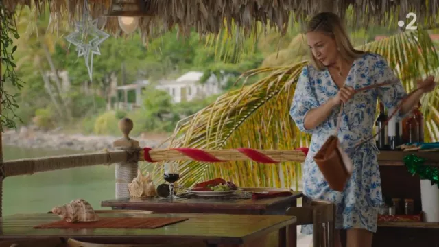 The white wallet dress with blue patterns worn by Sophie Chambers (Chelsea Edge) in the series Murders in Paradise