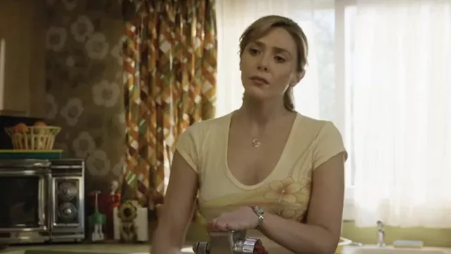 Camiseta amarilla floral usada por Candy Montgomery (Elizabeth Olsen) como se ve en el vestuario de la serie de televisión Love & Death (Temporada 1)