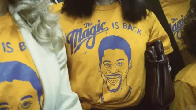 "The Magic is Back" Magic Johnson fan T-shirt in yellow as seen in Winning Time: The Rise of the Lakers Dynasty (Season 2)