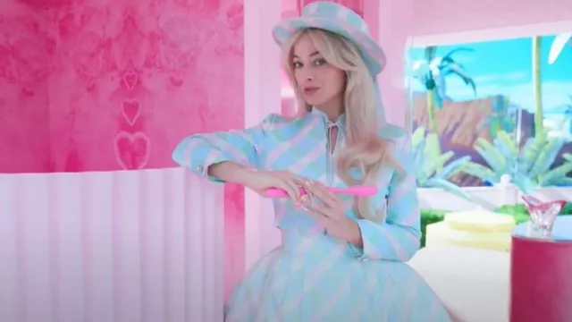 The pastel blue dress striped with pink worn by Barbie (Margot Robbie) in  the movie Barbie