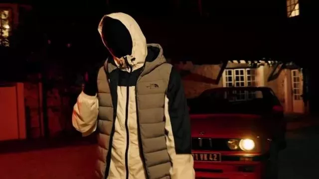 The North Face sleeveless down jacket with hood worn by menace Santana in his music video Guapman