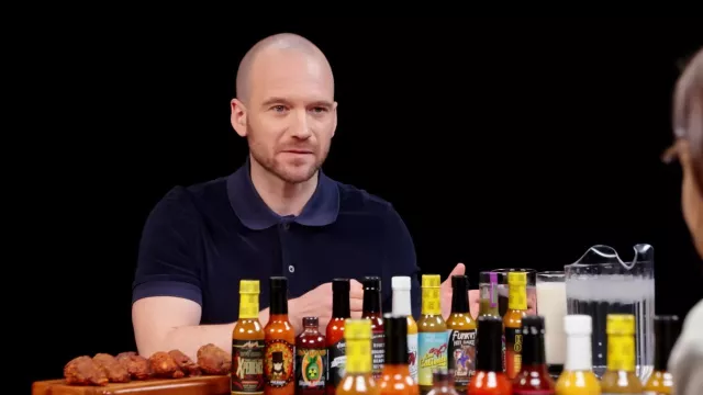Navy blue polo shirt worn by Sean Evans as seen in Hot Ones on March 2024
