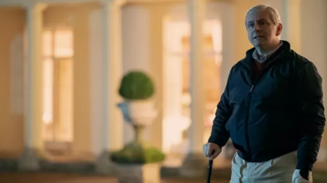 Atuendos de A Very Royal Scandal Temporada 1: El príncipe Andrés (Michael Sheen) lleva una chaqueta Harrington con cremallera en el episodio 3 de la temporada 1