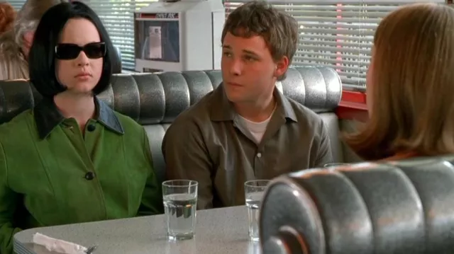 Tenues du film Ghost World : Enid (Thora Birch) porte une veste verte avec des garnitures en cuir noir et des boutons noirs